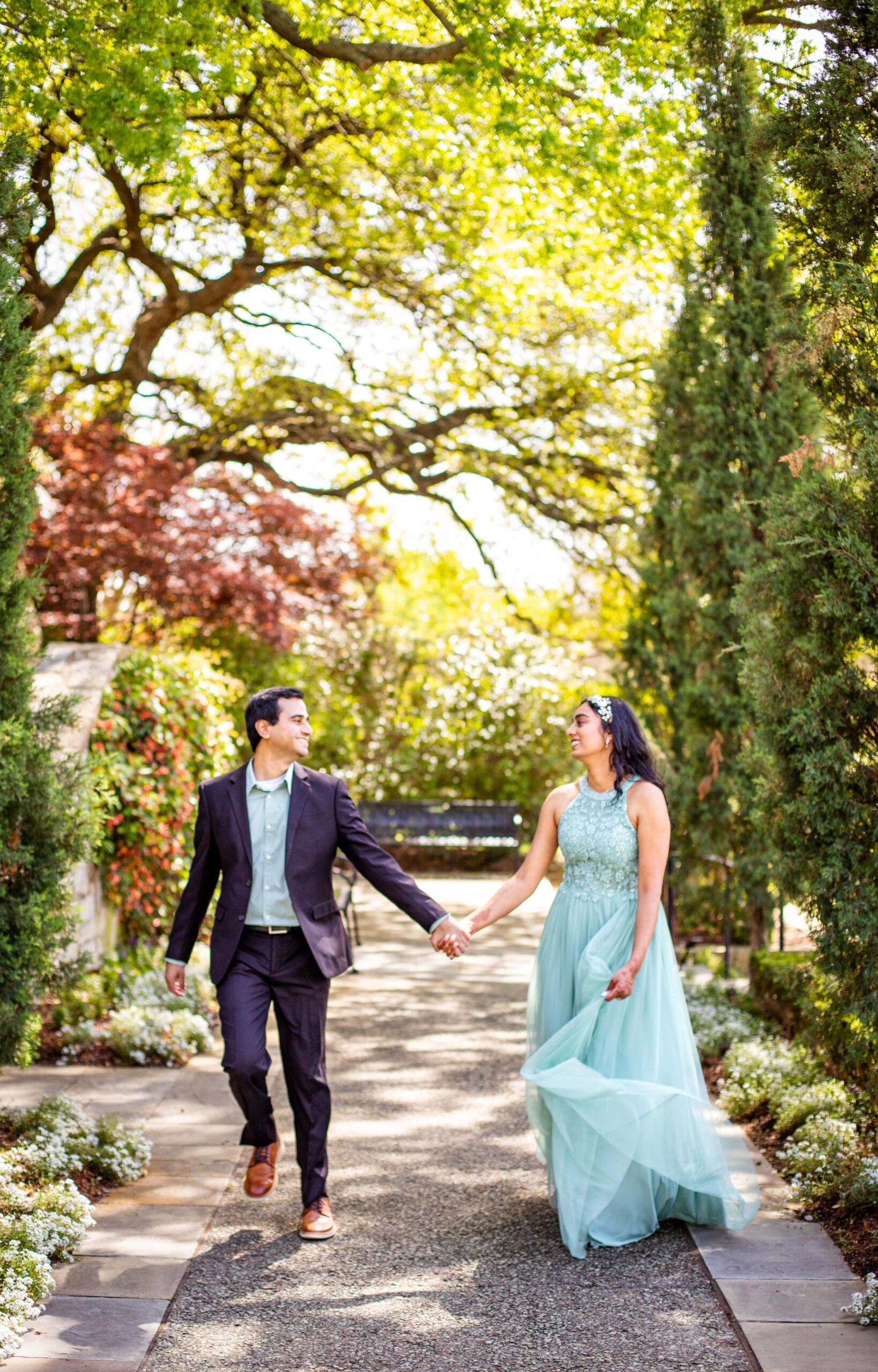Engaged couple running at the Dallas Arboretum