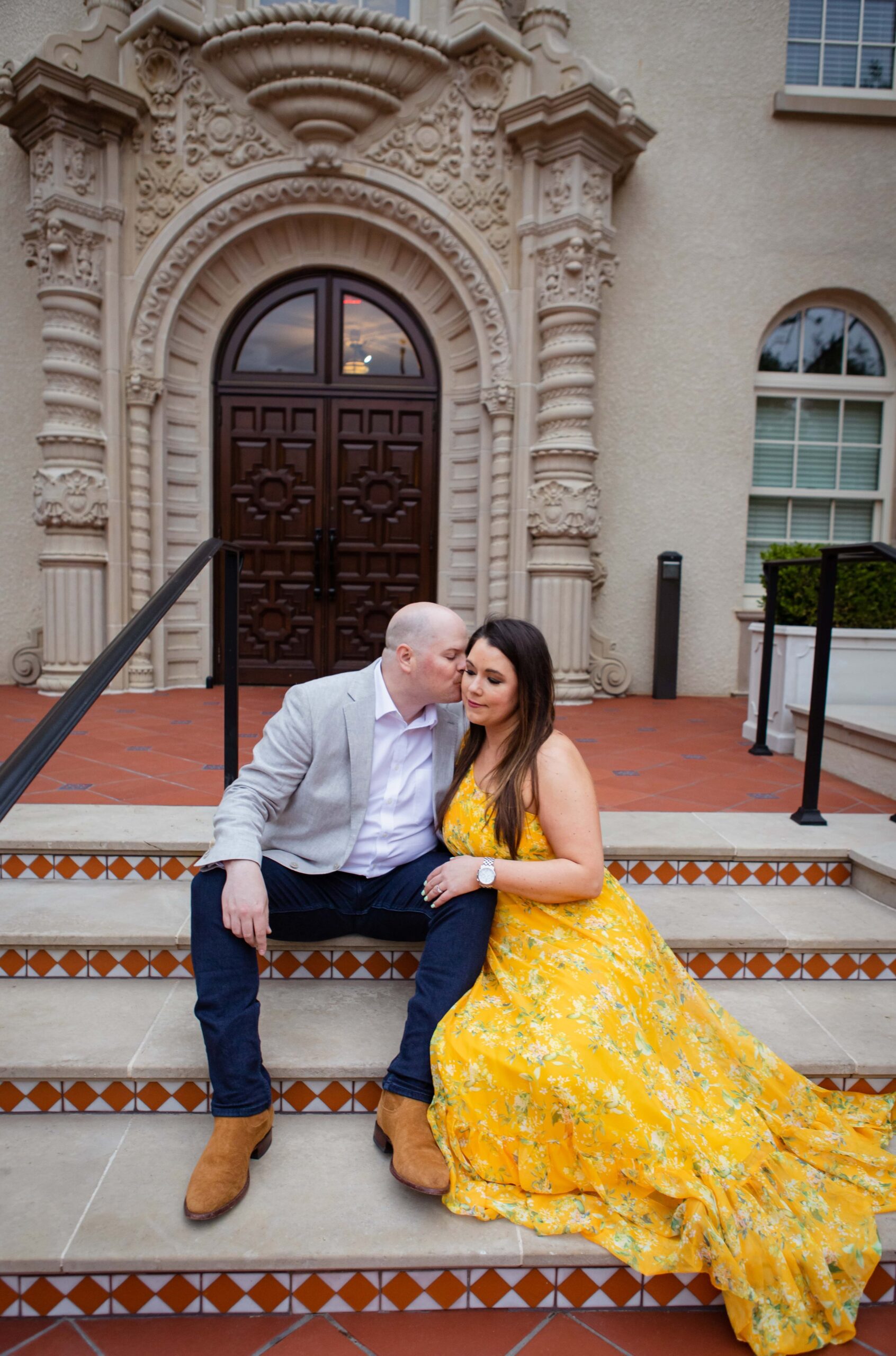 Couple sitting for engagement photos at Highland Park Village steps
