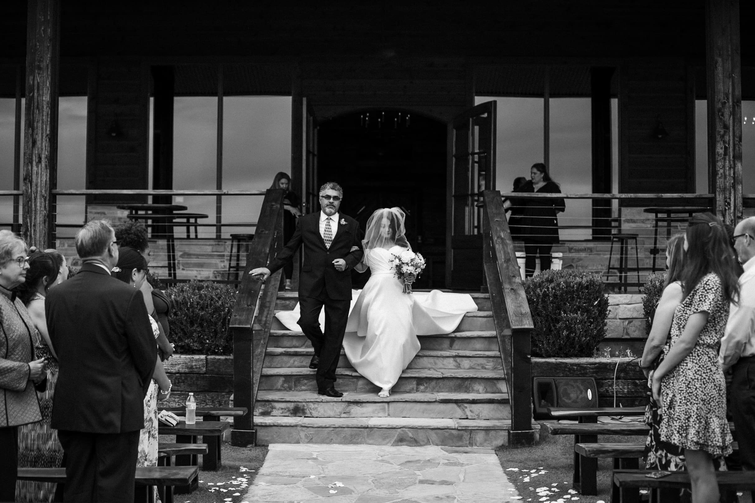 Dramatic editorial photo of bride walking down the aisle in black and white